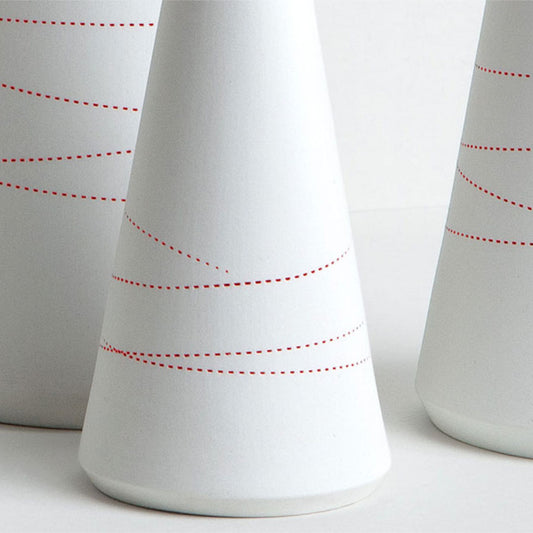 Porzellanvase mit geprägten roten Linien.