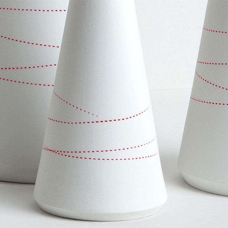 Porzellanvase mit geprägten roten Linien.